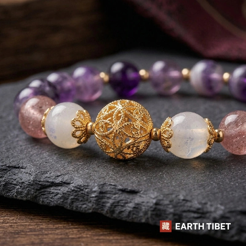 Close view of the hollow gold filigree bead between glowing white moonstone and flecked strawberry quartz
