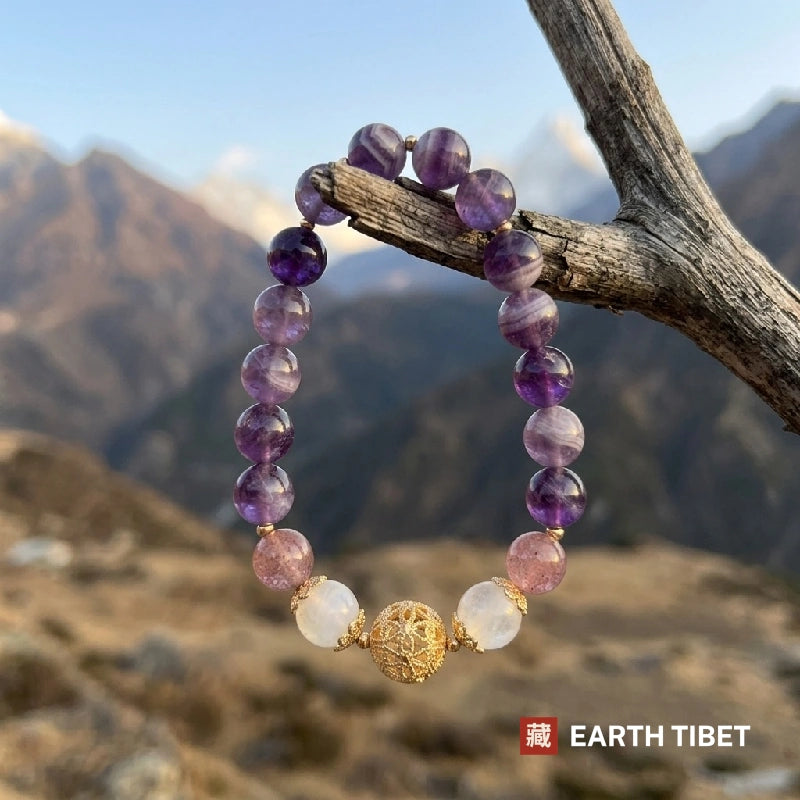 Moonstone and amethyst bracelet hanging from a branch in front of Himalayan peaks