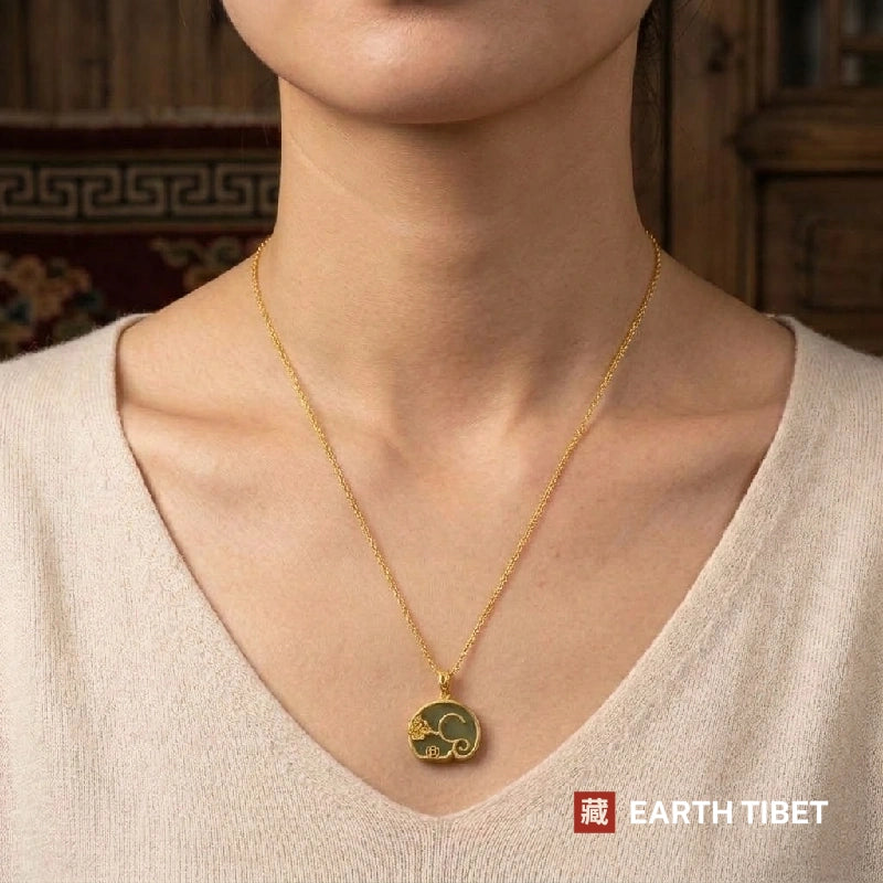Jade elephant disc necklace worn at the collar of a cream top