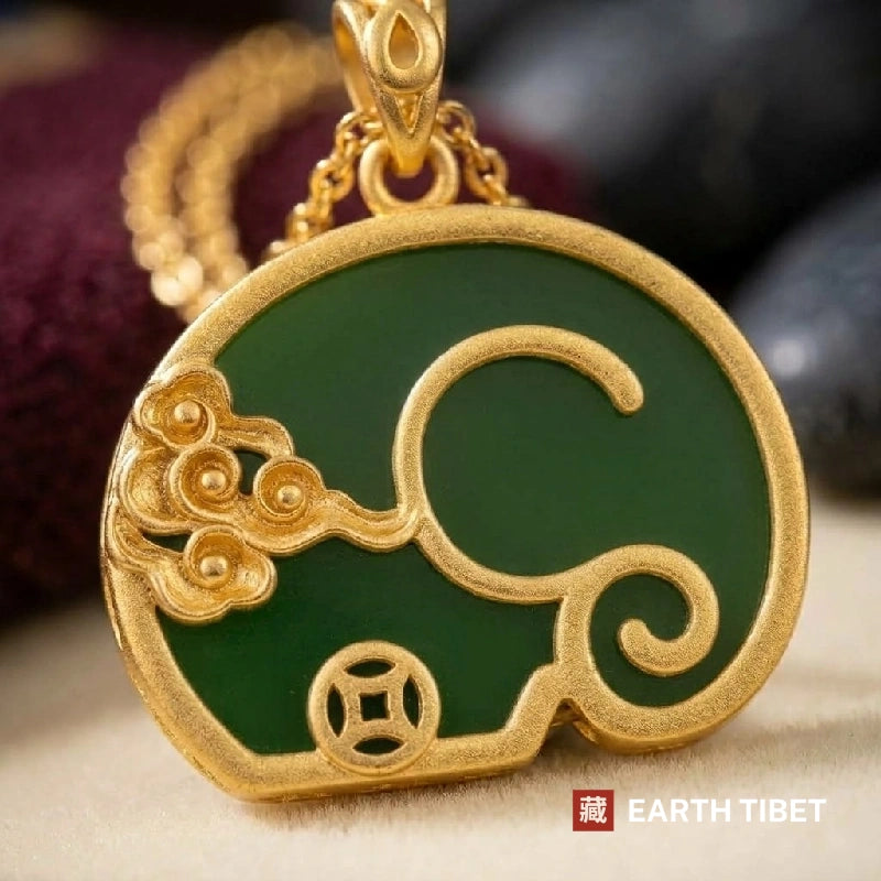 Close view of the gold elephant outline, cloud scroll and coin eye on deep green stone