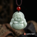 Jade laughing Buddha pendant on a braided cord with a red agate bead