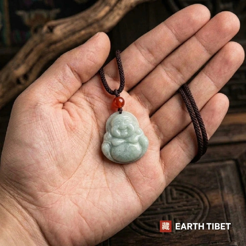 Jade laughing Buddha necklace lying in an open hand to show its size