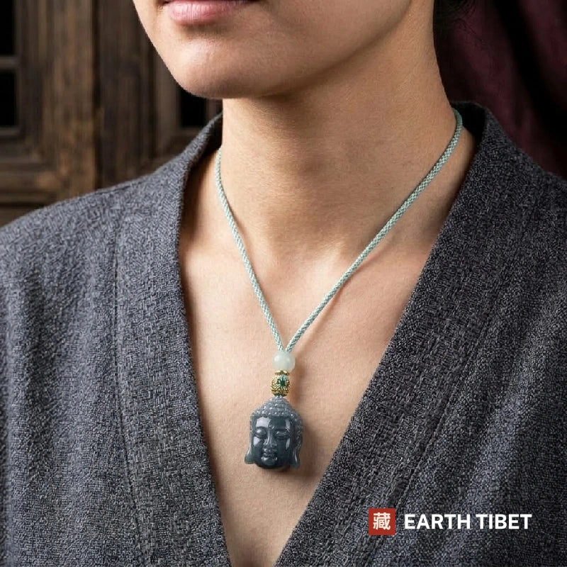 Woman wearing the jadeite Buddha head necklace over a grey cardigan on a mint cord