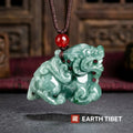 Green jadeite pixiu pendant on a brown braided cord with a red agate bead