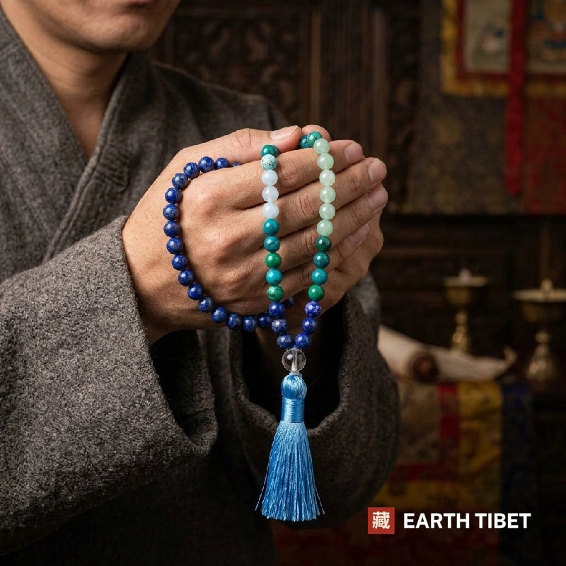 Lapis lazuli mala held in two joined palms, showing the length and the blue silk tassel