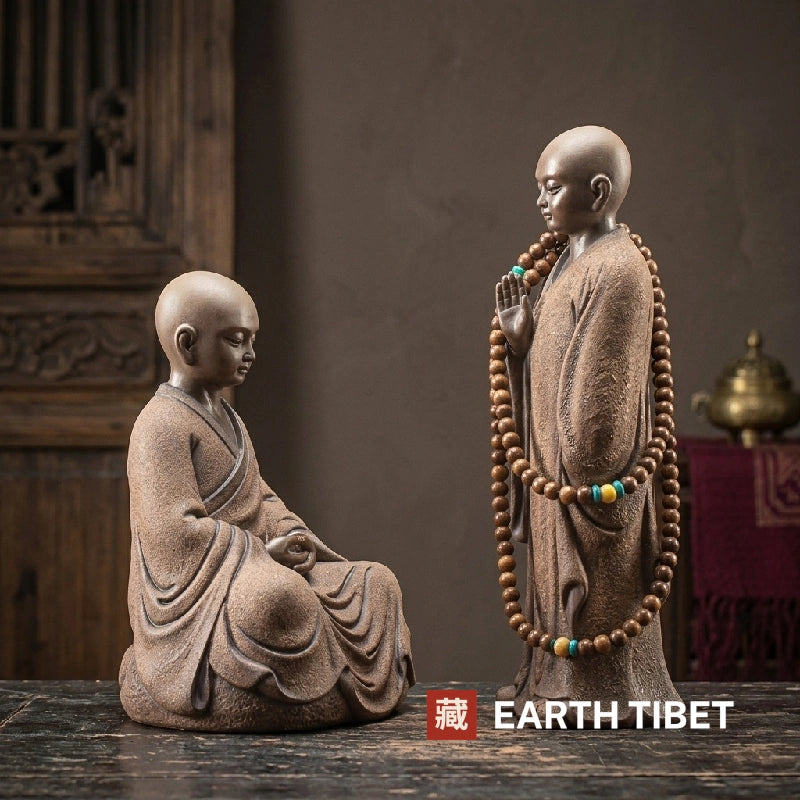 Seated and standing monk statues facing each other in profile