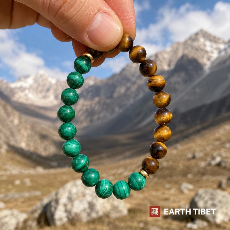 Malachite and tiger eye bracelet on slate beside a carved wooden box