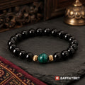 Black tourmaline bracelet with a single malachite bead set between two fluted gold rings