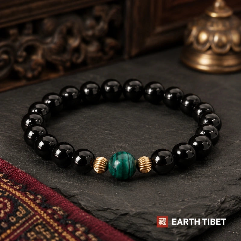 Black tourmaline bracelet with a single malachite bead set between two fluted gold rings