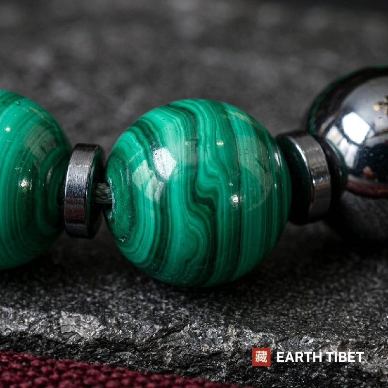 Malachite hematite bracelet photographed flat on dark stone