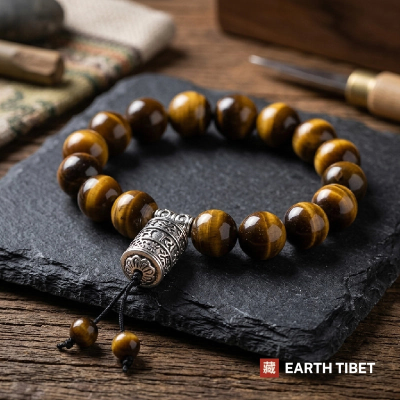Twelve millimetre tiger eye bracelet with a Tibetan silver mantra barrel, on slate