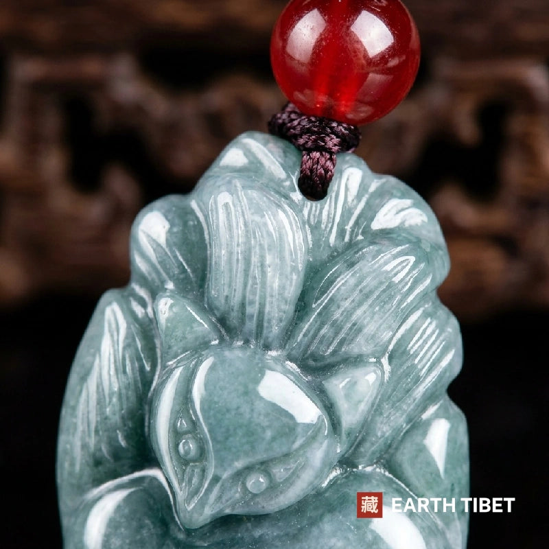 Macro of the carved fox head and fanned tails in pale blue-green jadeite
