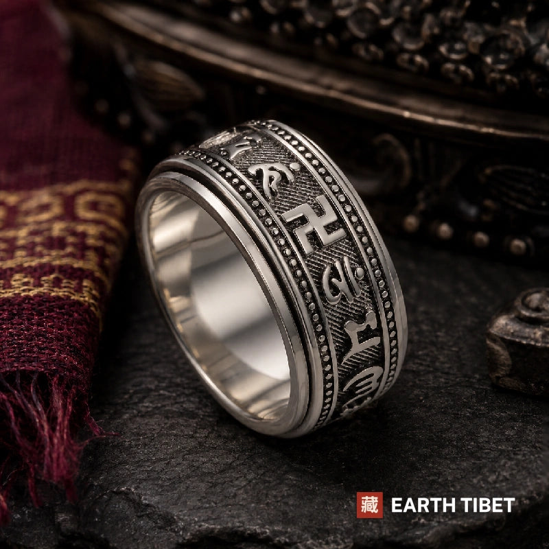 Om mani padme hum spinner ring on slate, raised Tibetan script and the spinning outer band visible