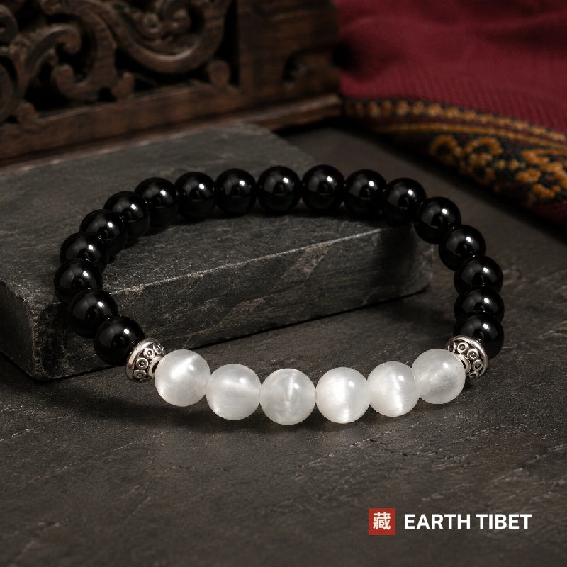 Full circle of the balance bracelet showing the dark onyx half and the white selenite half