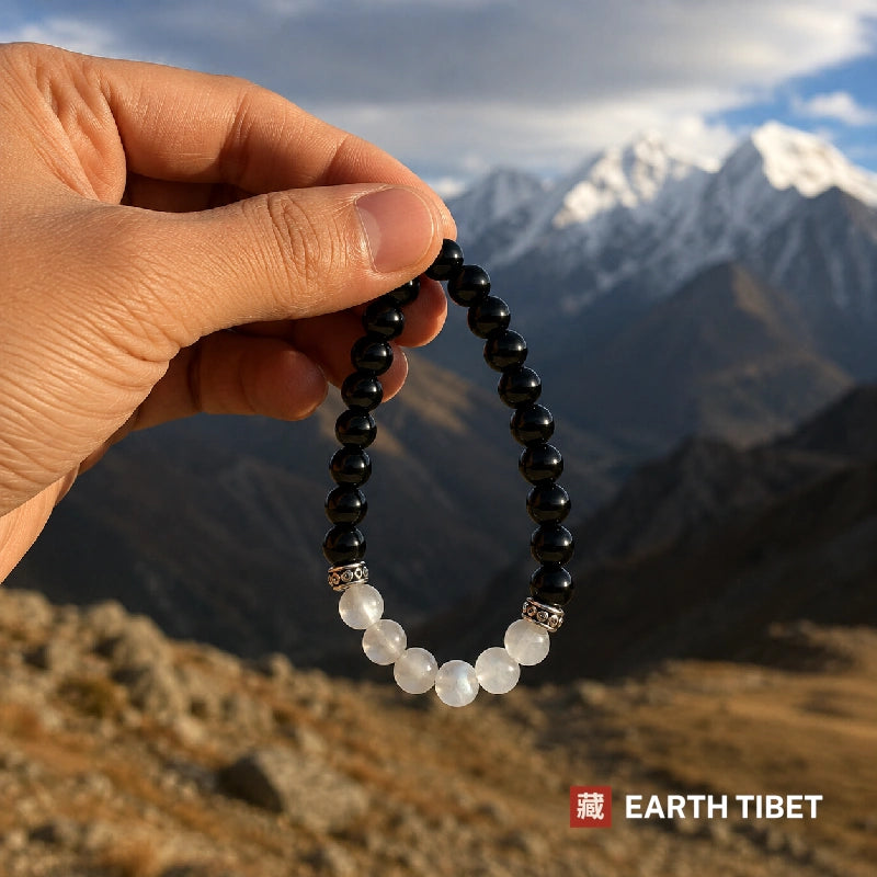 Onyx and selenite stretch bracelet against carved wood