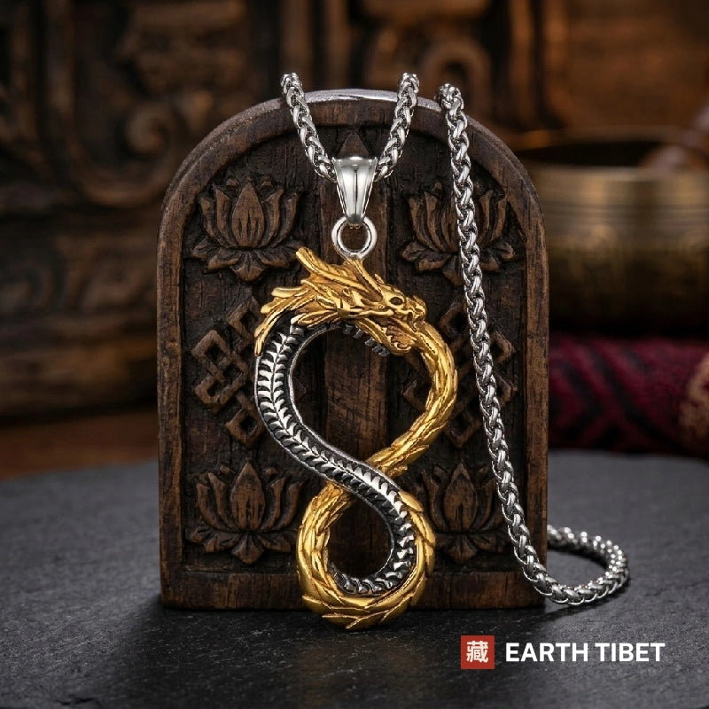 Coiled dragon pendant in stainless steel and gold tone, 58mm, on dark slate