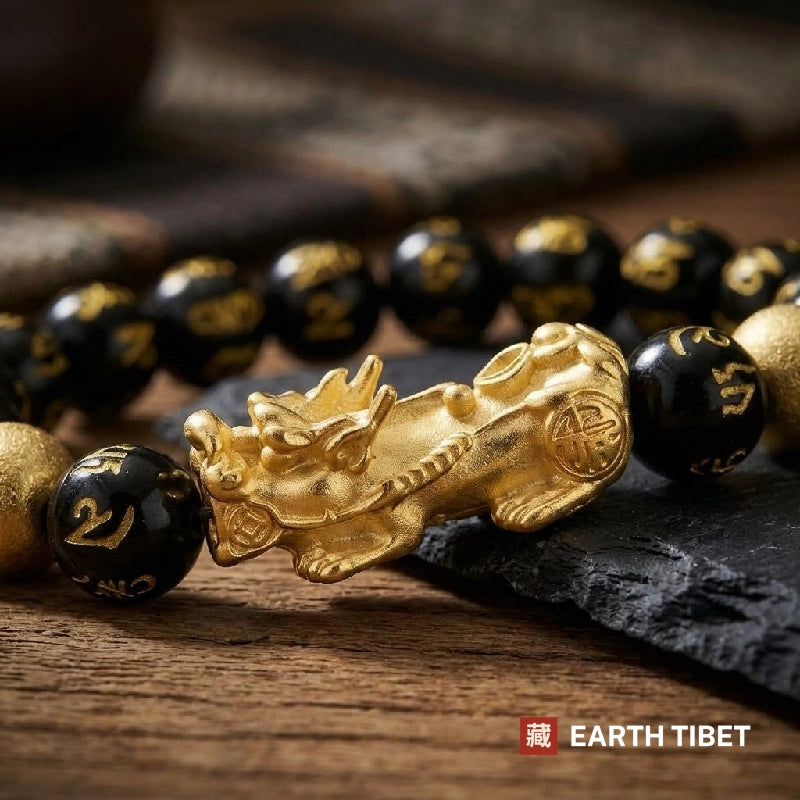 Close view of the gold-filled Tibetan script carved into the black beads