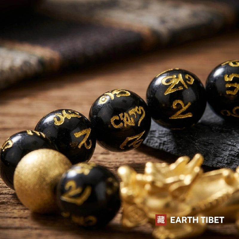 Macro of the mantra beads beside the matte gold bead and the pixiu
