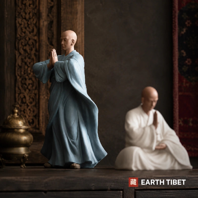 Chinese praying monk statues styled on a wooden shelf