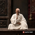 Seated praying monk statue in cream, hand raised in the do-not-fear gesture