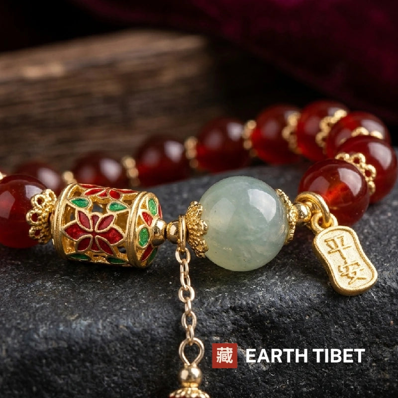 Close view of the cloisonne barrel, pale green bead and gold ping an tag on red agate