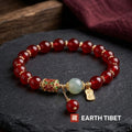 Cloisonne red agate peace bracelet laid flat on dark slate