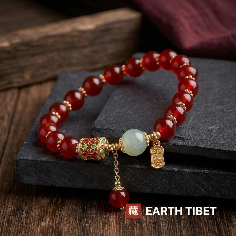 Red agate bracelet angled on slate blocks showing the gold chain drop