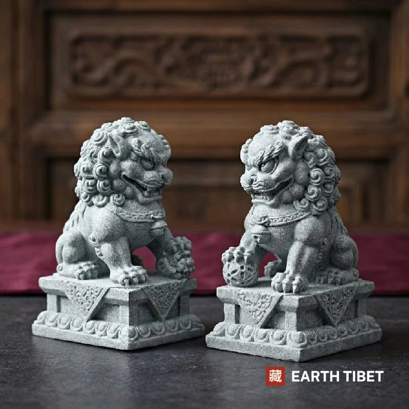 Guardian lion pair facing inward, one paw on an embroidered ball and one on a cub