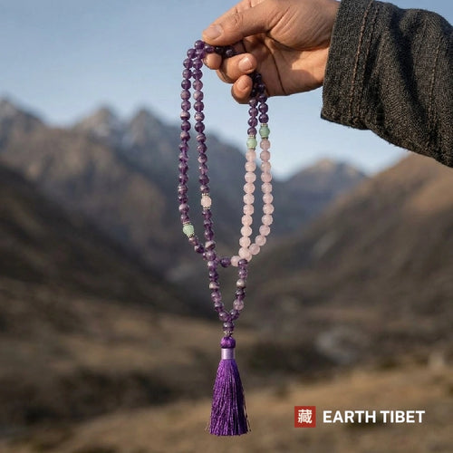 Self love mala held up in front of Himalayan mountains