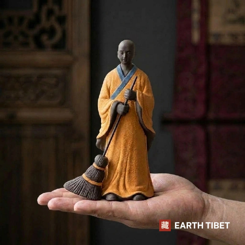 Sweeping monk statue resting in one open palm to show its size