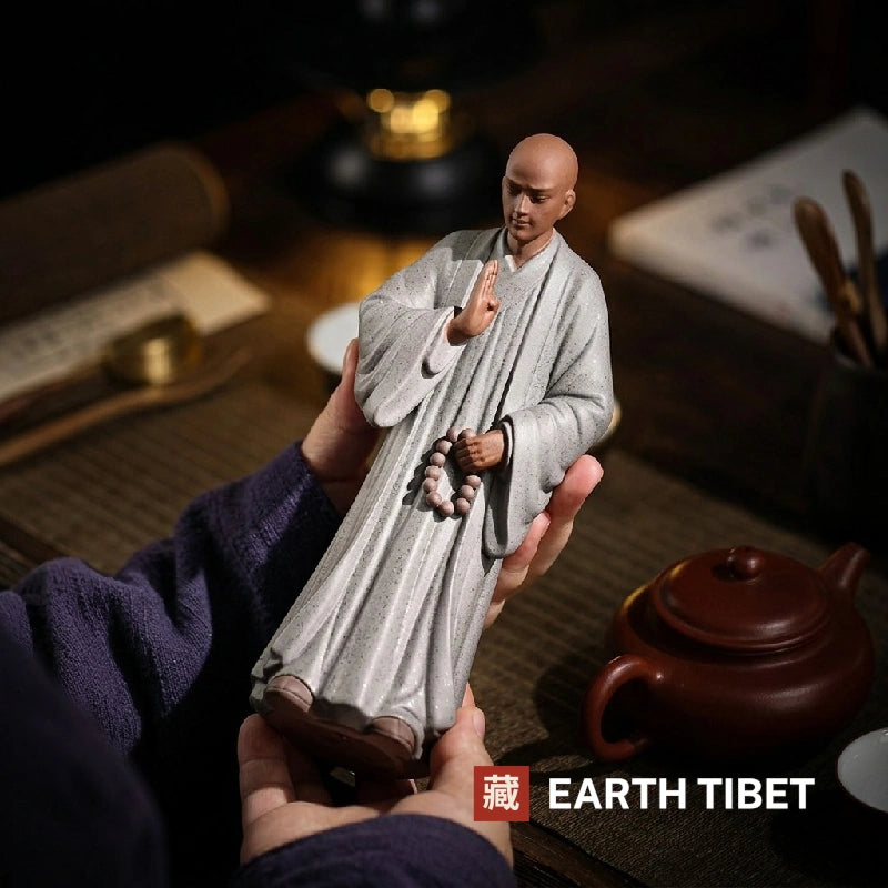 Tall zen monk ceramic statue held in two hands to show its size