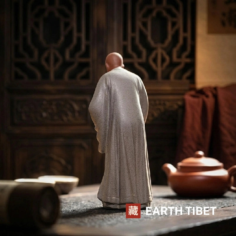Back view of the tall zen monk ceramic statue showing the fall of the robe