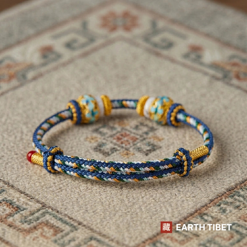 Blue protection cord bracelet with two blue and gold enamel beads
