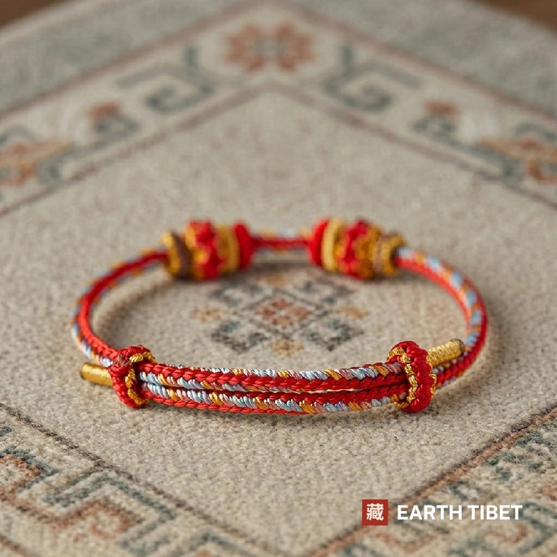 Red protection cord bracelet with two knotted red and gold beads