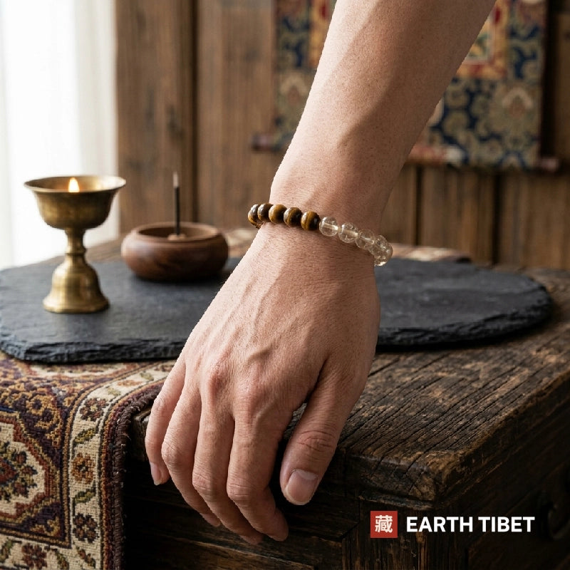 Citrine tiger eye bracelet worn on a wrist beside a butter lamp