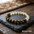 Citrine and tiger eye beads photographed on a dark slate tile