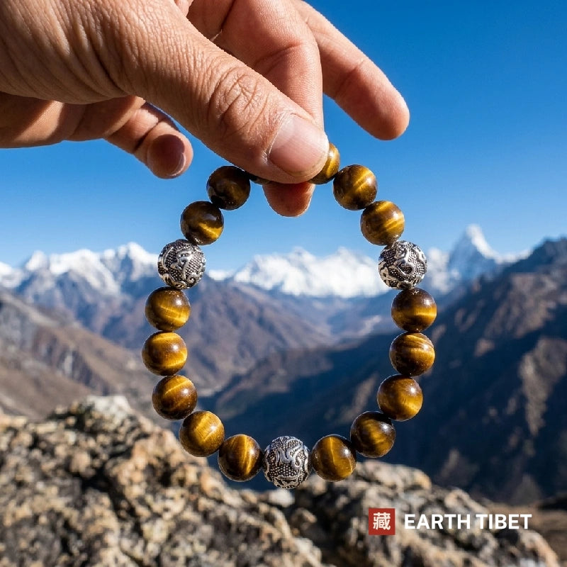 Tiger eye mantra bracelet held up against snow-capped mountains