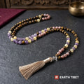 Full length of the sunstone tiger eye mala laid out on slate beside a singing bowl