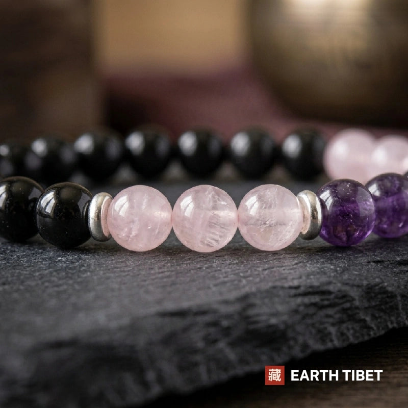 Close view of milky rose quartz beads between black tourmaline and deep purple amethyst