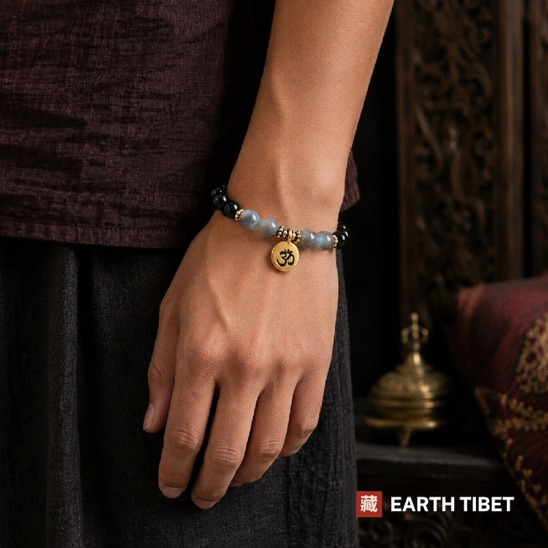 Labradorite protection bracelet worn on a wrist against a maroon linen sleeve