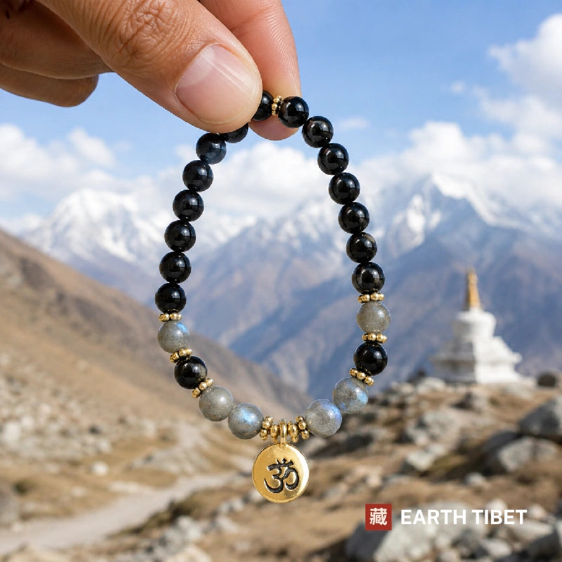 Labradorite tourmaline bracelet held against the Himalaya beside a white Tibetan stupa