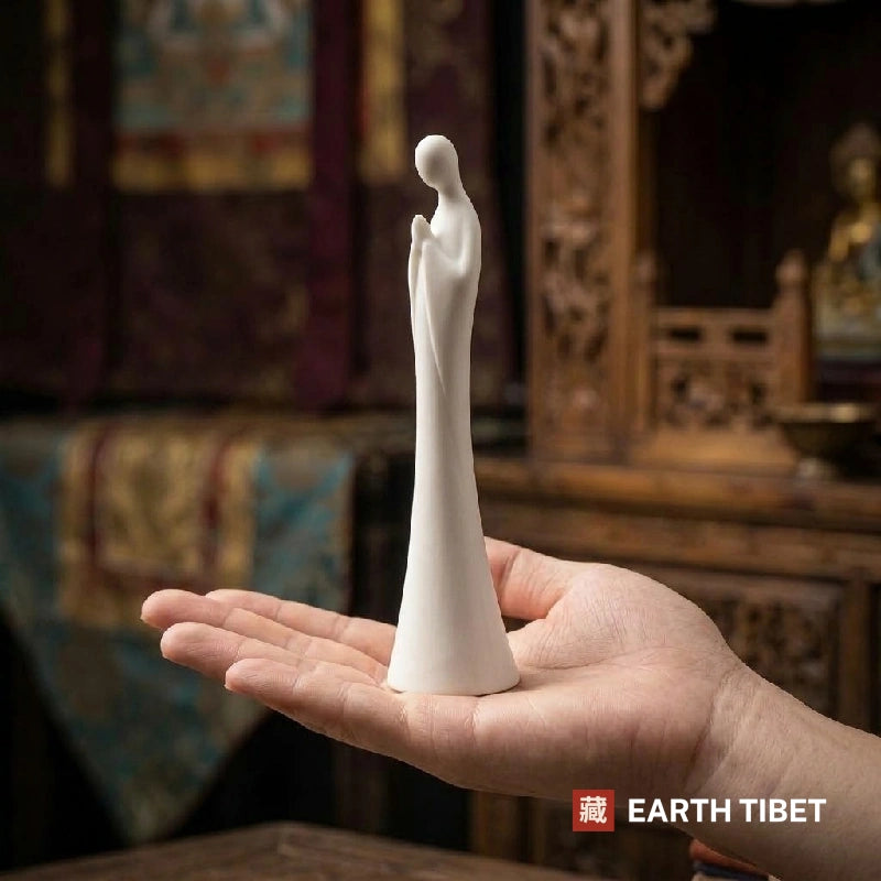 White faceless zen statue standing in an open hand to show its size
