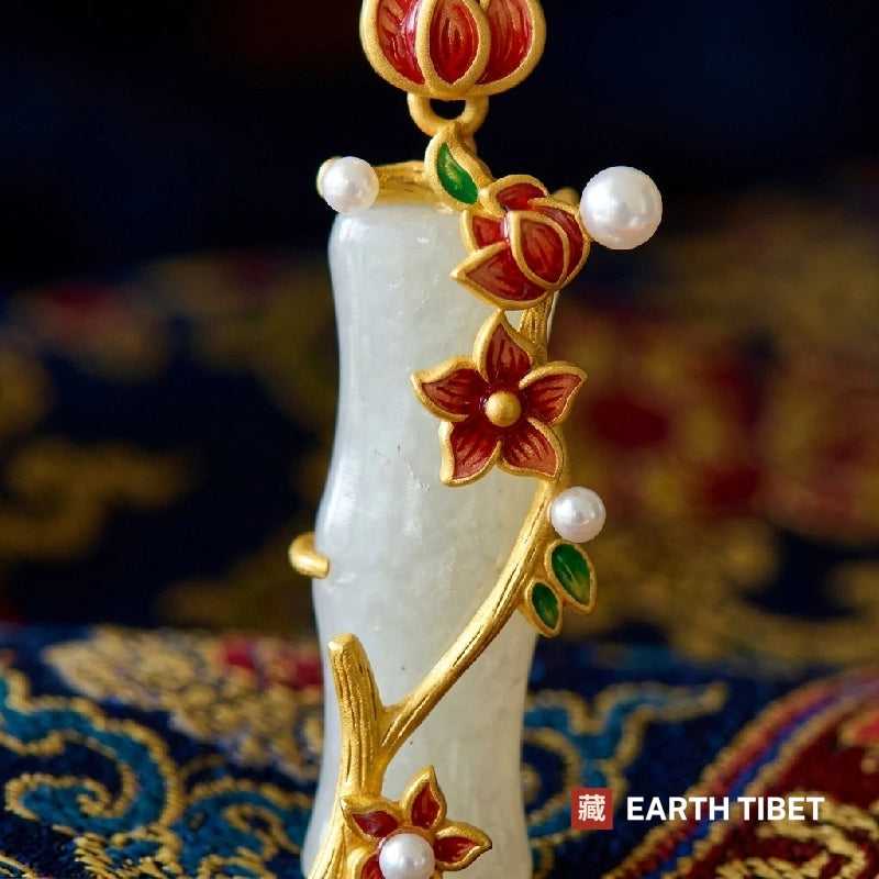 Close view of the plum branch, enamel flowers and white beads against the carved bamboo