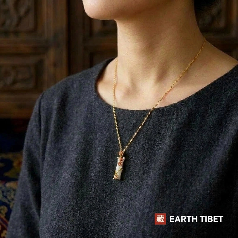 Bamboo blossom necklace worn at the collar of a grey wool top