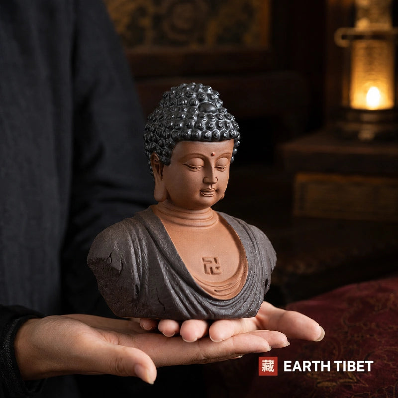 Ceramic Shakyamuni Buddha bust with downcast eyes and elongated earlobes