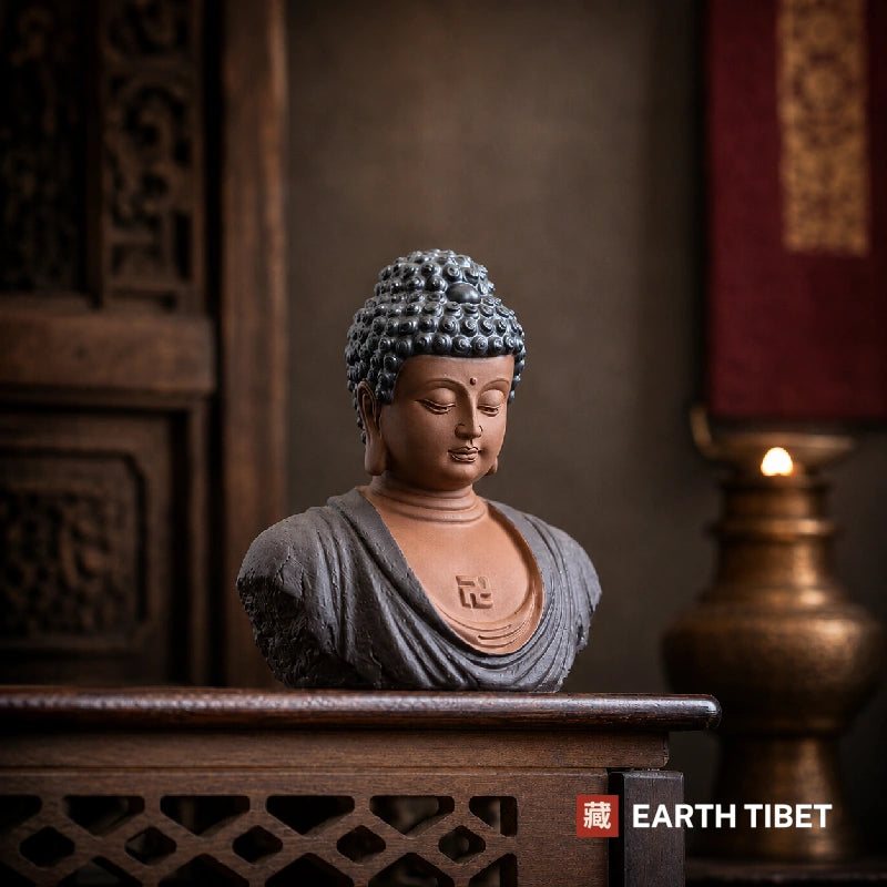 Buddha bust in slate blue, the robe matte against unglazed terracotta