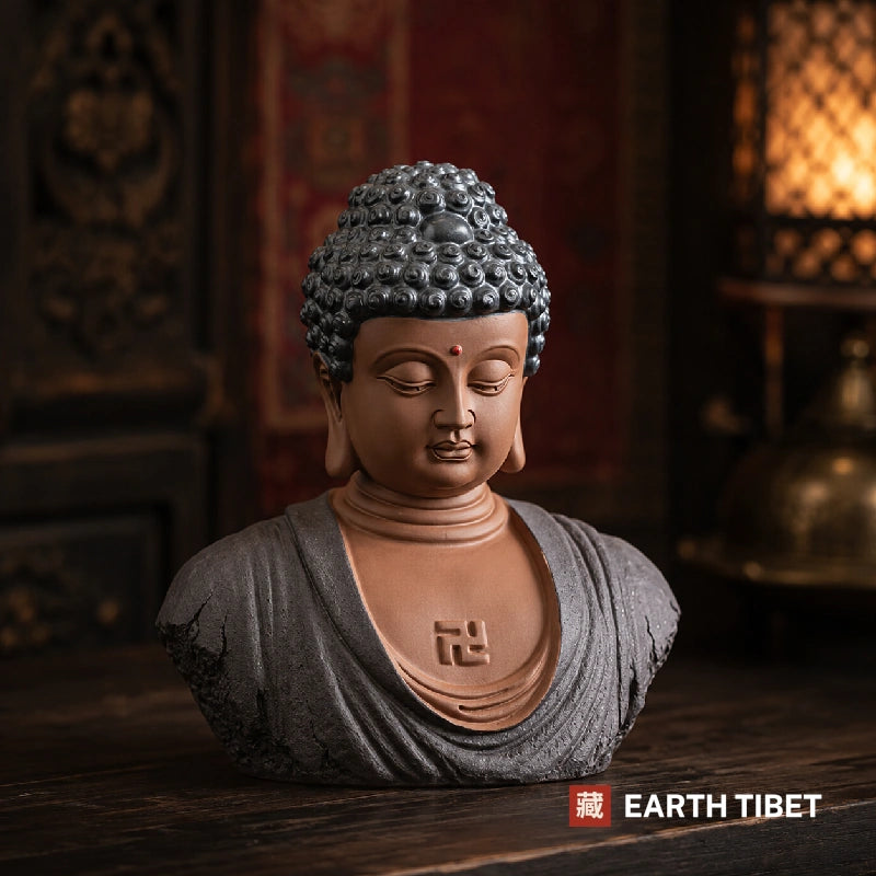 Pale green-grey Buddha head statue on a dark surface