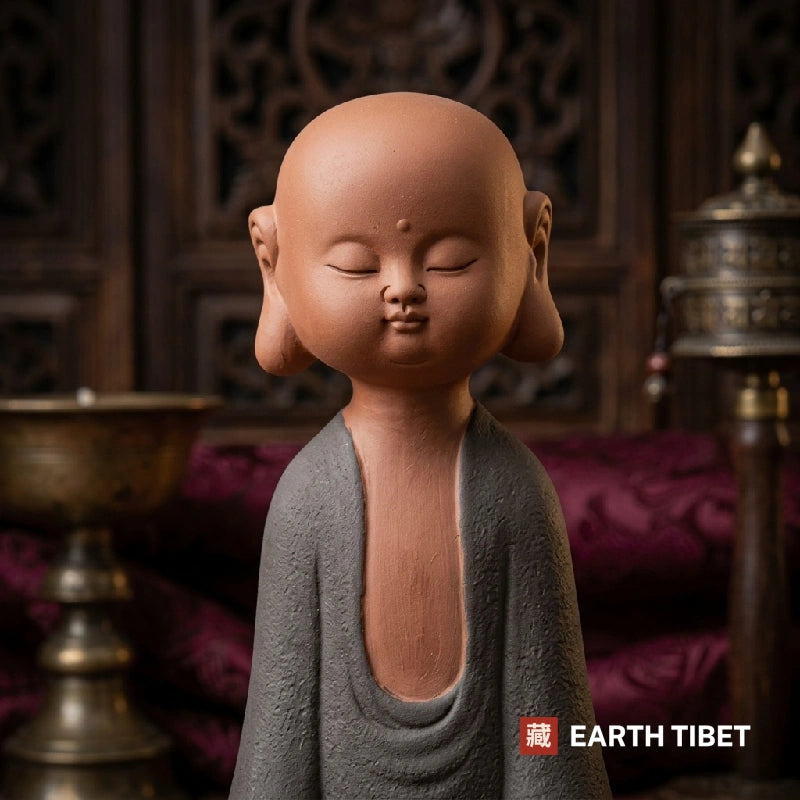 Close up of the meditation gesture, right hand resting over left, on the novice monk statue