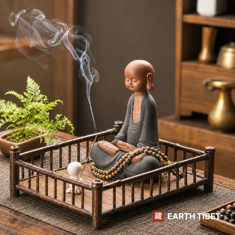 Novice monk statue styled on a bamboo tray with incense and a mala, both shown as props