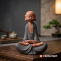 Front view of the novice monk statue, shaved head, closed eyes and long ears